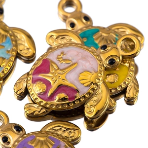 Macro view of gold turtle charms with colorful enamel sea shell patterns for DIY jewelry