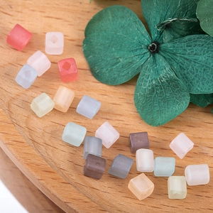 Macro shot of 4mm matte pastel square beads with center holes for DIY jewelry making