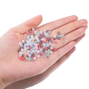 Mix of 4mm macaron colorful square acrylic beads held in hand for DIY jewelry making