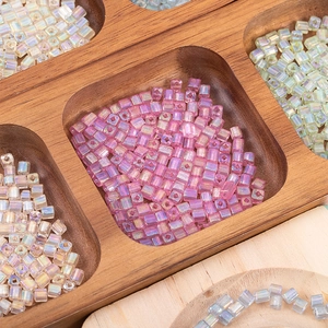 Macro shot of 4mm cube beads with AB rainbow coating in a wooden organizer tray
