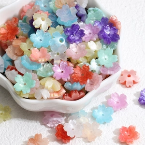 Makroansicht bunter transluzenter Blumenperlen aus Harz für DIY-Schmuck in einer Schale