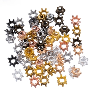Close-up of hollow crown jewelry spacers in gold, silver, bronze and black metal