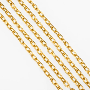 Close-up of golden oval aluminum chain links with intricate cross-embossed grid texture
