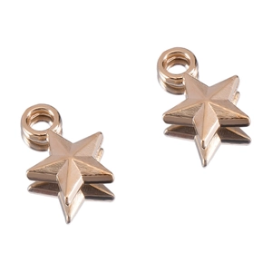 Macro shot of gold five-pointed star pendants with radiant engraved texture details