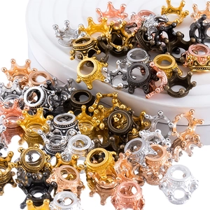Detailed macro view of crown jewelry pendants in five metallic finishes on a white stand
