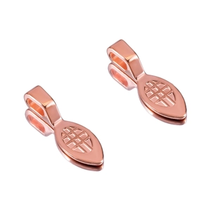 Close-up of rose gold shovel-shaped jewelry clasps with textured geometric patterns
