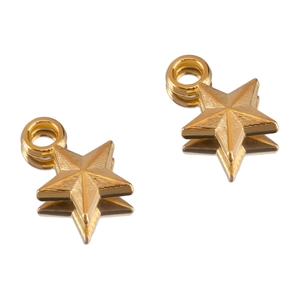 Macro detail of 3D star-shaped golden brass pendant charms with textured radial patterns