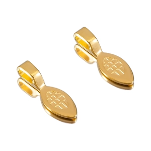 Macro detail of golden vintage shovel pendants with intricate engraved mesh texture