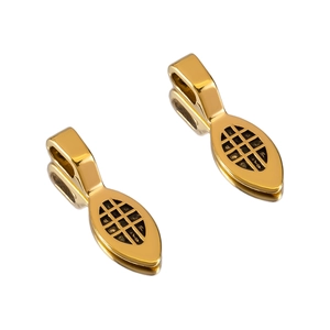 Detail of vintage gold alloy oval charms with black grid pattern for DIY jewelry making