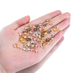 Multicolor star pendants for DIY jewelry making held in hand for size visualization