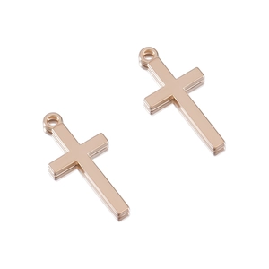 Macro detail of rose gold cross pendants with smooth mirror reflection on white surface