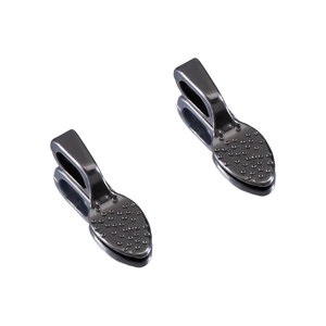 Macro detail of teardrop metal connector clasps with textured dot pattern in dark grey