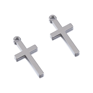Close-up of two polished silver cross pendants with rings for jewelry making