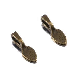 Macro detail of bronze alloy leaf-shaped charms with granular texture for DIY jewelry