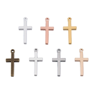 Detailed view of polished metal cross pendants in seven different metallic finishes