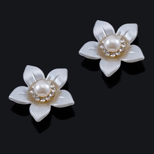 Detalle de accesorios de pétalos de flores con perla central y borde de cristales