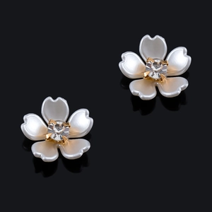 Detalle de elegantes pendientes de flores de nácar con un centro de circón brillante