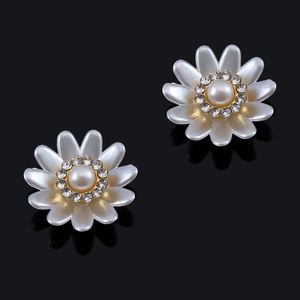 Detalle de pendientes de margarita con centro de perla y borde de brillantes strass