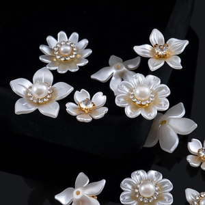 Detalle de colgantes de flores de resina y perlas para accesorios de pelo de novia