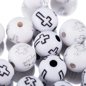 Vista macro de cuentas acrílicas blancas con símbolos de cruz para joyería artesanal