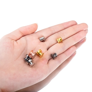 Polished magnetic badge pin backs in four colors held for size demonstration