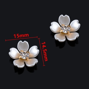 Detalle de los pendientes de flor de perla de 15mm con cristal engastado en garra dorada