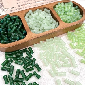 Macro view of bamboo-shaped glass loose beads in shades of green for DIY jewelry