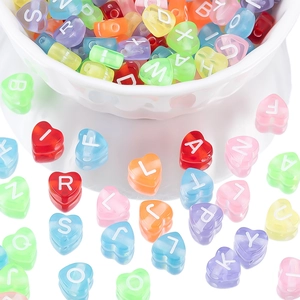 Detalle macro de cuentas acrílicas de corazón con letras para joyería artesanal