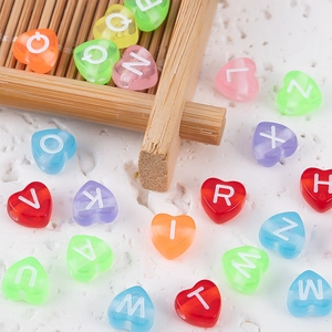 Primer plano de cuentas de acrílico coloridas con letras para joyería artesanal