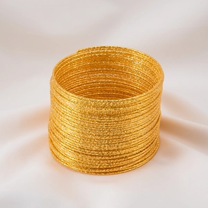 Detailed macro shot of multilayer gold coils with glittering textured finish for DIY jewelry