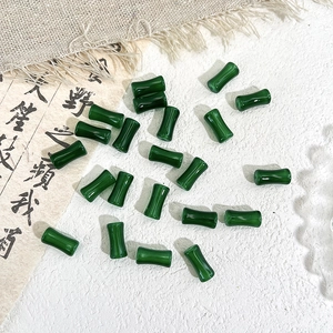 Macro view of dark green bamboo shaped glass beads on a minimalist zen style background