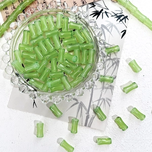 Macro detail of translucent green bamboo-shaped glass beads for DIY jewelry making