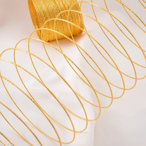 Macro shot of minimalist multi-layer gold steel coil bracelet with diamond-cut texture