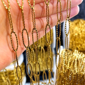 Close-up of golden stainless steel oval link chain with textured surface for jewelry DIY