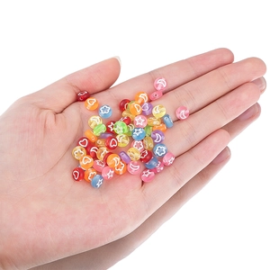 Cuentas acrílicas de colores con estrellas y corazones en la mano para joyería artesanal
