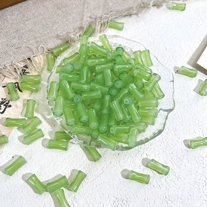 Macro shot of translucent light green bamboo-shaped glass beads for DIY jewelry making