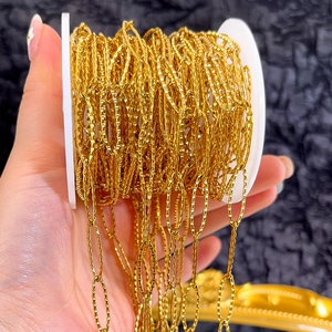 Detailed macro view of golden diamond-shaped DIY jewelry chain with engraved textures