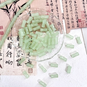 Detailed macro view of light green bamboo-shaped glass beads for DIY jewelry making