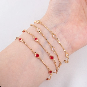 4mm gold twisted chain bracelet with red and white gemstones worn on wrist