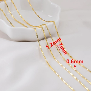 Makroaufnahme einer goldenen DIY-Schmuckkette mit 1,2x7 mm Gliedern auf Keramik