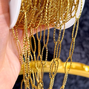 Macro shot of gold-plated stainless steel chain with textured oval links on a spool
