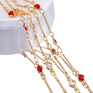 Macro view of 4mm gold-plated chain with ruby and clear crystal gemstones for DIY jewelry