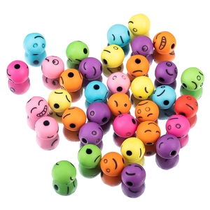 Primer plano de cuentas acrílicas de colores con caritas sonrientes para joyas DIY