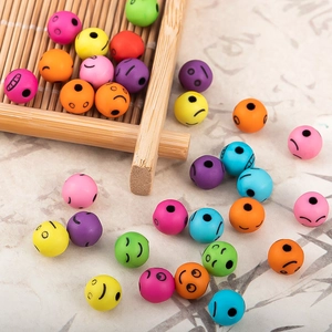 Primer plano de cuentas acrílicas de colores con caras para joyería DIY en bandeja bambú