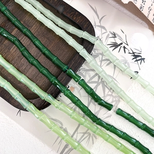 Detailed close-up of bamboo-shaped glass beads for DIY jewelry with elegant jade-like texture