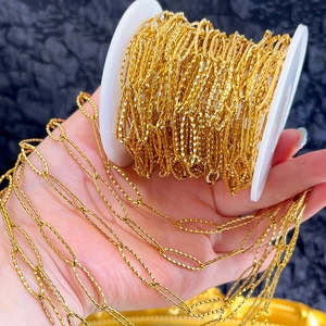 Macro detail of golden stainless steel diamond-cut chain on a spool for DIY jewelry