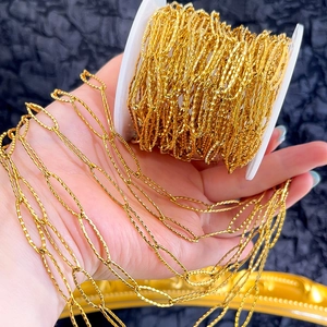 Close-up of golden textured oval links chain for DIY jewelry making displayed on a roll