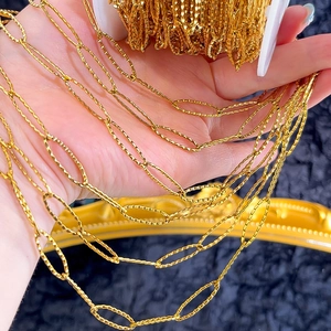 Macro view of textured gold stainless steel diamond shaped DIY jewelry chains on hand