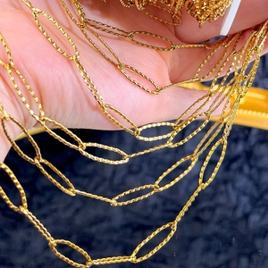 Macro detail of golden stainless steel oval links with diamond texture for jewelry DIY