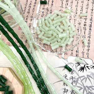 Macro detail of bamboo-shaped glass beads in light and dark green for DIY jewelry